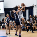St. Paul Warriors Niah Siguenza powers through Academy Cougars Mia San Nicolas for a shot in the paint. (Photo by Michael Blas)