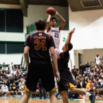St. Paul Warriors Reo Aiken pops for a high jumper over FD Friars Brandon Soriano. (Photo by Michael Blas)