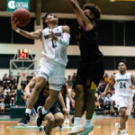 St. Paul Warriors Jahmar White attacks the basket on a fast break while FD Friars Tony Quinene contests. (Photo by Michael Blas)