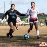 St. Paul Warriors Lovely Nilooban and Eli Errett chases the ball down the sidelines to keep it in play. (Photo by Michael Blas)