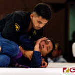Peter Benevente (black) finishes his opponent Don Rasa (blue) near the midway point of the Purple Belt Bout. (Photo by Michael Blas)