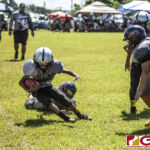 Island Broncos Ethan James Castro gets the tackle on the sidelines from Guam Raiders Ethan Guerrero. (photo by Bout It Productions)