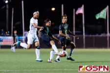 JFK Islander Alexander Shambach clears the ball off of Harvest Eagles James Lee. (Photo by Michael Blas)
