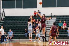 St. Paul Warrior Audrey Dela Cruz sinks in a three against FD Friar Matthew Fegurgur. (Photo by Michael Blas)