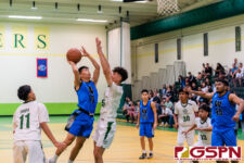 St. Paul Warrior Hayato Tsujii drives towards the basket against JFK Islander Dean Weilbacher. (Photo by Michael Blas)