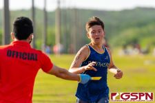 A Guam High Panther runner reaches for his number at the finish line. (Photo by Michael Blas)