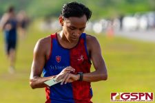 A St. John's Knight runner checks his time after finishing the race. (Photo by Michael Blas)
