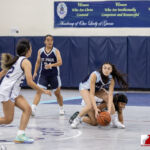 Academy Cougar Mia Taitano attempts a steal against St. Paul Warrior Jan Quintanilla. ( photo by Bout It Productions )