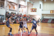 Friar guard Jeremiah David takes on three Warriors on his way to the basket. (photo by Raine Delos Reyes)