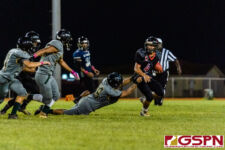 JFK Islander Adam Babauta breaks through the line for a tackle on SHS Dolphin Zavier Camacho. (Photo by Michael Blas)
