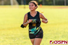 JFK Islander Chastity Minor loops around the track in her race against the Okkodo Bulldogs. (Photo by Michael Blas)