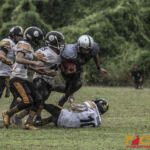 Guam Raiders Kin John San Nicolas jumps over Tamuning Steelers Lance Muna Aguon for extra yardage. (photo by Bout It Productions)