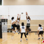 Okkodo Bulldog Jessie Martin powers the ball past two Tiyan Titans defenders. Photo by Bout It Productions.
