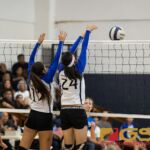 St. Paul Christian Warrior's Keiani Pangelinan, left, and Niah Siguenza, right, blocks a spike from Norte Dame Royal's Nicollete Perez. (Photo by Michael Blas)