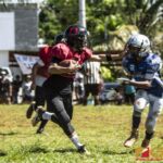 Faha Outlaws Zavier Camacho introduces the stiff arm to Southern Cowboys Raymond Blas. (photo by Bout It Productions)