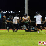 JFK Islander RB Jacobe Quinata gets powers through Dolphins Noah Stanley for a gain on the play. (Photo by Michael Blas)