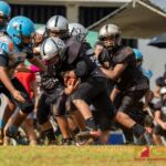 Raiders Peter Mesa drives the ball forward as Angels Josiah Mendiola looks to make the tackle. (Photo by Michael Blas)