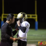 Tiyan High Coach Cj gives the next play to his Qb Kaekoa Leon Guerrero. (photo by Bout It Productions)