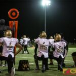 The Tiyan High Titans take a knee on the sidelines for an injured player. (photo by Bout It Productions)