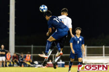 Harvest Eagle Micah Hennegan and JFK Islander Juan Sarmiento leap up to head the ball. (Photo by Michael Blas)