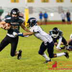 JFK Islander's Aiden Quitagua tries to get away from Guam High Panther's Ruben Ramirez. (Photo by Michael Blas)