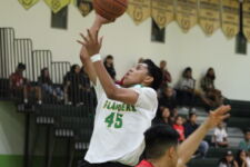 JFK Islander Rodson Simina attacks the basket early in the opening quarter. (photo by Robert Balajadia)