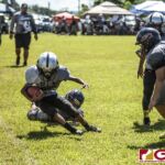 Island Broncos Ethan James Castro gets the tackle on the sidelines from Guam Raiders Ethan Guerrero. (photo by Bout It Productions)