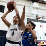 St. Paul Warriors Xander Sanchez scores in the paint against Bishops Coen Valencia. (Photo by Michael Blas)