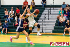 JFK Islander KJ Camacho gets down court on a fast break while Academy Cougar's Coco Paulino pressures. (Photo by Michael Blas)