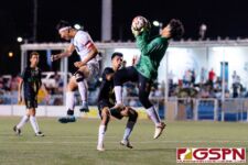 JFK Islander Goalkeeper Allan Aranas gets ahold of the ball before Harvest Eagle James Lee can take a chance at goal. (Photo by Michael Blas)