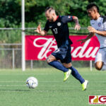 Philippines Captain Stephan Schrock maintains possession of the ball in midfield while Guam Matao Midfielder Ian Mariano trails him. (Photo by Michael Blas)