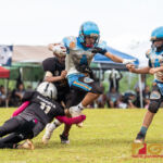Raiders Javier Babauta hangs onto Angels Noah Castro to complete the tackle. (Photo by Michael Blas)