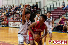 Okkodo Bulldog Rylen Cavigal finds the basket while FD Friar Kyle Camacho defends. (Photo by Michael Blas)