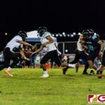 JFK Islander QB Allen Blend hands off to Dysseus Quintanilla for the crash straight down the middle. (Photo by Michael Blas)