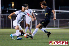 Harvest Eagle James Lee maneuvers the ball around JFK Islander defender Emilio Babauta. (Photo by Michael Blas)