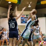 St. Paul Warriors Niah Siguenza takes a fade away jumper with Academy Cougars Mia San Nicolas contesting. (Photo by Michael Blas)