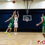 Harvest Eagles Kyo Gele goes for three while JFK Islanders Jerry Ngraremiang gets a hand up. (Photo by Michael Blas)