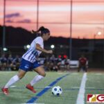 Guam High Panthers Alexandra Hawkes controls the ball down field as the Cougars bench looks on. (photo by Bout It Productions)