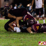 FD Friar Evan Brown and Elijah Calvo get a huge hit on Islander RB Jacobe Quinata. (Photo by Michael Blas)