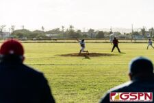 ND Royal Coaches staff watches on as Ethan Lobaton launches a pitch in the third inning. (Photo by Michael Blas)