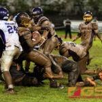JFK Islanders Chase Spotanski and Kyler Aguon prevent GW Geckos Jose San Miguel from spinning away. (Photo by Michael Blas)