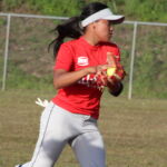 Southern Dolphin Vanesha Naputi prepares to fire off a throw to 1st base. Sanchez Shark Ginae Joseph tries to tag a sliding runner for an out. (photo by Robert Balajadia)