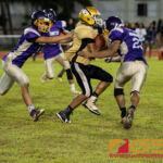 Tiyan Titans John Angoco sneaks to the sidelines, gaining enough yardage for the first down. (Photo by Michael Blas)