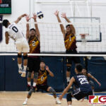 St. Paul Warriors Jonathan Sevilla send the ball over the net while Friars Logan Pangelinan and Brian Anderson contests. (Photo by Michael Blas)