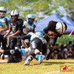 Angels Gerell Cruz and Jayden Tomagan makes the tackle on Raiders Peter Mesa. (Photo by Michael Blas)