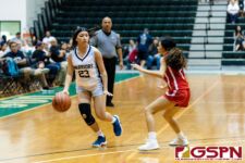 St. Paul Warrior Kayla Senne gets set to run the play while St. John's Knight Yasmeen Lopez defends. (Photo by Michael Blas)