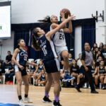 St. Paul Warriors Niah Siguenza powers through Academy Cougars Mia San Nicolas for a shot in the paint. (Photo by Michael Blas)