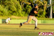 JFK Islander Vince Camacho hits a grounder towards third base to get to first. (Photo by Michael Blas)