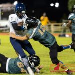 JFK Islander's Chase Spotanski slams Guam High Panther's Sincere Powell early in the first quarter. (Photo by Michael Blas)