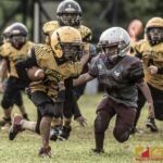 Guahan Eagles Zhien-Drayce Nauta carries the ball for extra yardage while Barrigada Crusaders Josiah Terlaje looks for the tackle. (photo by Bout It Productions)